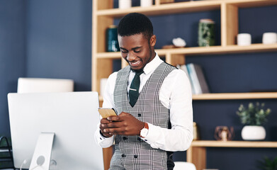 Smile, typing and black man in office with phone for online research, email and communication at...
