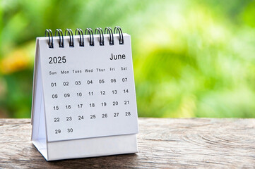 June 2025 white table calendar with customizable space for text. Calendar concept and copy space.