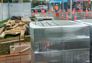 Bricks wrapped in plastic on a construction site. Unrecognizable worker keeping the traffic moving. Auckland. - 790665743