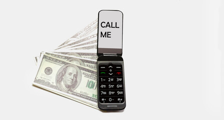 Mobile phone with text Call me. There are dollars nearby on a white background