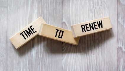 The word RENEWAL TIME is written on wooden blocks on a gray table.