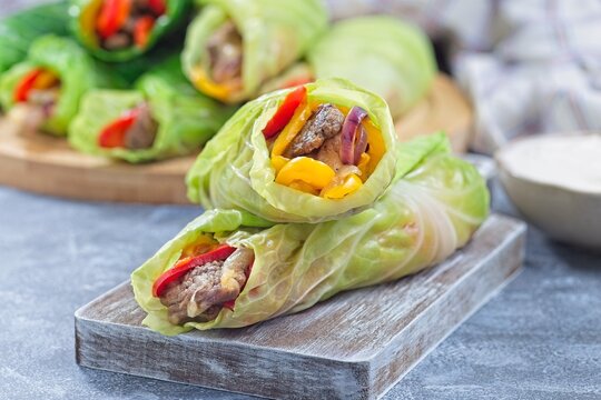 Beef and vegetable cabbage leaves wraps, served with plain yogurt, horizontal