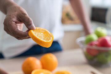 Man holding cut half of orange fruit. Slice of Orange.