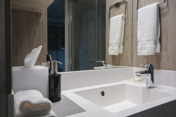 Modern design bathroom with sink, shower, towels and mirror and mosaic tiles in cabin or stateroom...