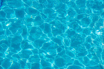 Swimming pool bottom caustics ripple and flow with waves background. Summer background. Texture of...