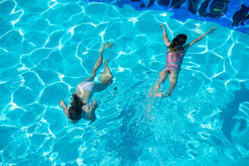 Naklejka premium kids swimming in pool underwater.