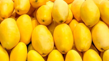 Vibrant, fresh, yellow mangoes neatly aligned offer a tropical treat, tips for healthy diets,...