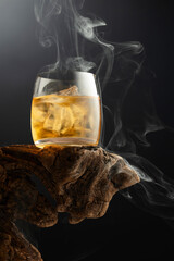 Whiskey with ice and smoke on a old snag.