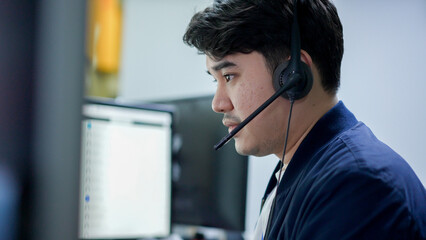 close up asian man call center agent wear headset device and  working in operation room with soling...