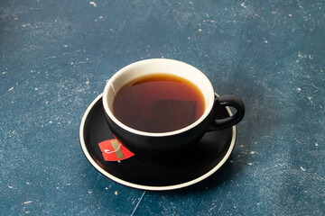Hot Black Tea with tea bag served on coffee cup isolated on background side view of hot drinkHot...