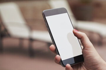 Mobile phone mockup with blank screen on white background for advertising, featuring a hand