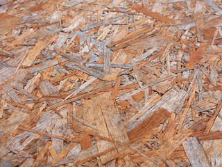 The texture and pattern of golden, brown, beige and gray wood chips in the building material - a...