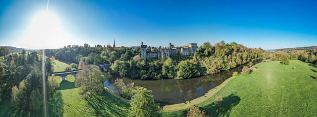 An aerial panorama reveals the majestic Lismore Castle in County Waterford, Ireland, set against a...