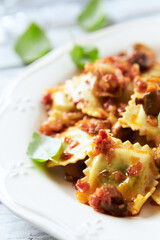 Ravioli with mushrooms and fresh basil. Bright wooden background. Close up