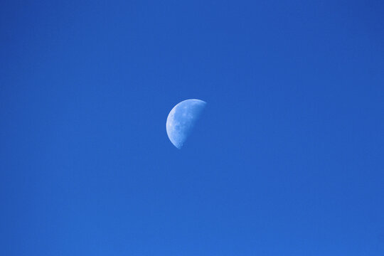 The Moon as Earths only natural satellite clearly visible in its Waning gibbous Moon phase on clear blue sky early in the morning