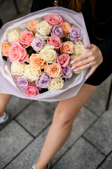 Close-up of a large bouquet of roses in a woman's hands