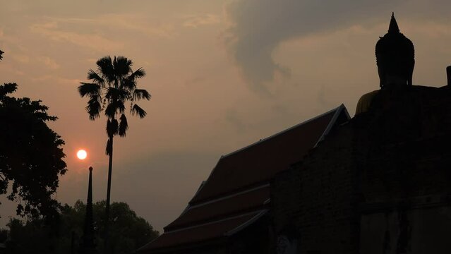 natural video background of the round sun rising from the horizon in the morning behind the old Buddha statue,Wat Yai Chai Mongkhon,is a beauty that happened spontaneously while traveling to Ayutthaya