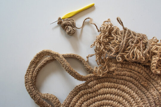 Round knitted bag made of twine, thread and 2mm hook for knitting on a white background