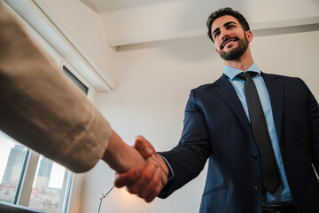 Confident businessman seals prosperous partnership deal in successful corporate handshake....