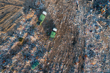 Aerial top down view of garbage trucks unload pile of waste at landfill. Dump of unsorted waste garbage pile in trash dump. Environmental pollution and ecological disaster. View from drone - 790727791