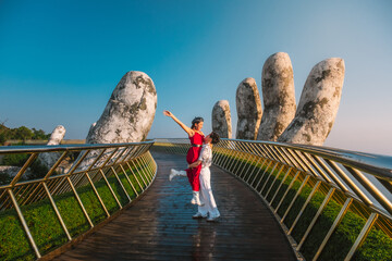 Young  traveler Couple  Walking on the Golden Bridge in Bana hills, enjoying the morning , Danang Vietnam