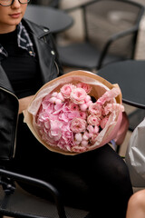 Large bouquet of pink hydrangeas, roses and other small flowers in kraft paper