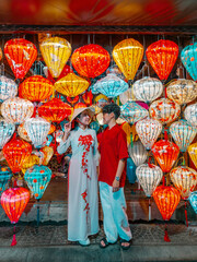 Asian Couple wearing vietnam  traditional culture  choosing lanterns  at Hoi An ancient town,Hoi an city in Vietnam.