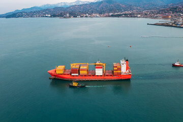 Aerial view of cargo ship loaded with containers for import and export, business logistic and transportation sail out sea port in Batumi, Georgia. Drone view. Freight shipping