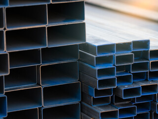 Industrial warehouse stock of rectangular metal pipes for building and construction supplies. Stack...