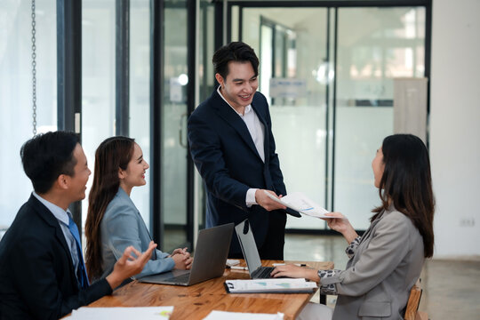 Male business leader handing over documents to a team member. Leadership and task delegation concept.