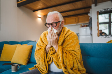 one senior man sit on sofa bed hold Paper tissue common cold sneezing