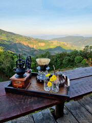 The set of coffee dripper makers on a wooden table and a blurred mountain background, Includes a...
