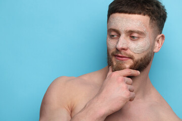 Fototapeta premium Handsome man with facial mask on his face against light blue background