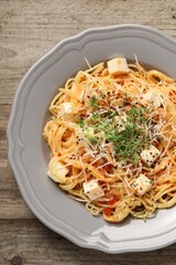 Vegetarian meal. Tasty pasta with fresh microgreens and cheese on wooden table, top view
