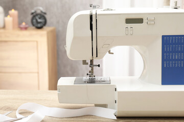 White sewing machine on wooden table indoors