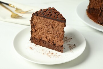 Piece of delicious chocolate truffle cake on white table, closeup