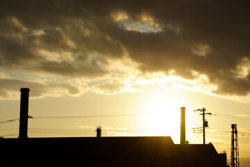 工業地帯の夕暮れと煙突のシルエット
