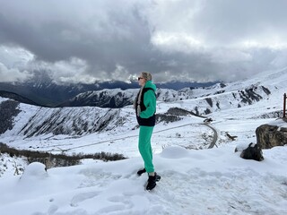 A woman on the background of the Ceylomsky pass in Ingushetia. A trip uphill to the Tsei Lum pass...
