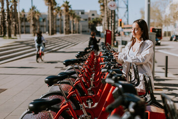 A serene spring afternoon in Barcelona with a smiling woman renting a bicycle