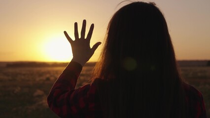 Young girl stretches out her hand to sun, dreams in nature. Sunrise in nature. Hand of happy child...
