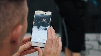 Woman filming a hairstyling session with her phone