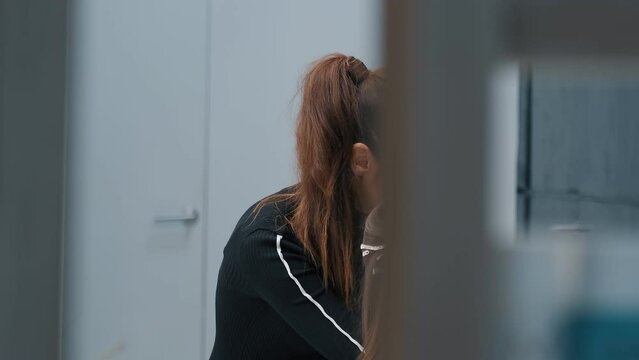 Concentrated hairdresser securing client's hair with clips at salon