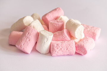 heap of sweet fluffy white and pink marshmallows on white surface close up