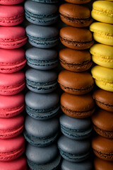Close-up of pink, blue, brown and yellow macaroons neatly lying in four rows