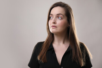 Fototapeta premium Portrait of beautiful woman on gray background, space for text