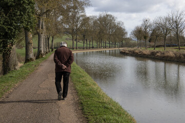 homme seul senior, âgé marchant le long du canal de Bourgogne