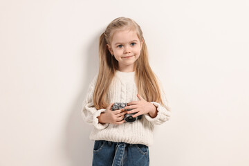 Fototapeta premium Fashion concept. Stylish girl with vintage camera on white background