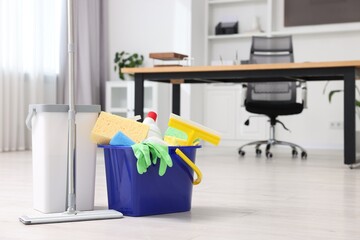 Cleaning service. Mop and bucket with supplies in office, space for text