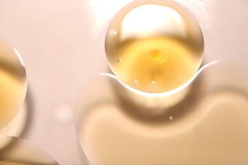 Yellow circular oil droplets floating on the water. - obrazy, fototapety, plakaty