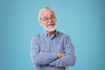 Portrait of stylish grandpa with glasses on light blue background